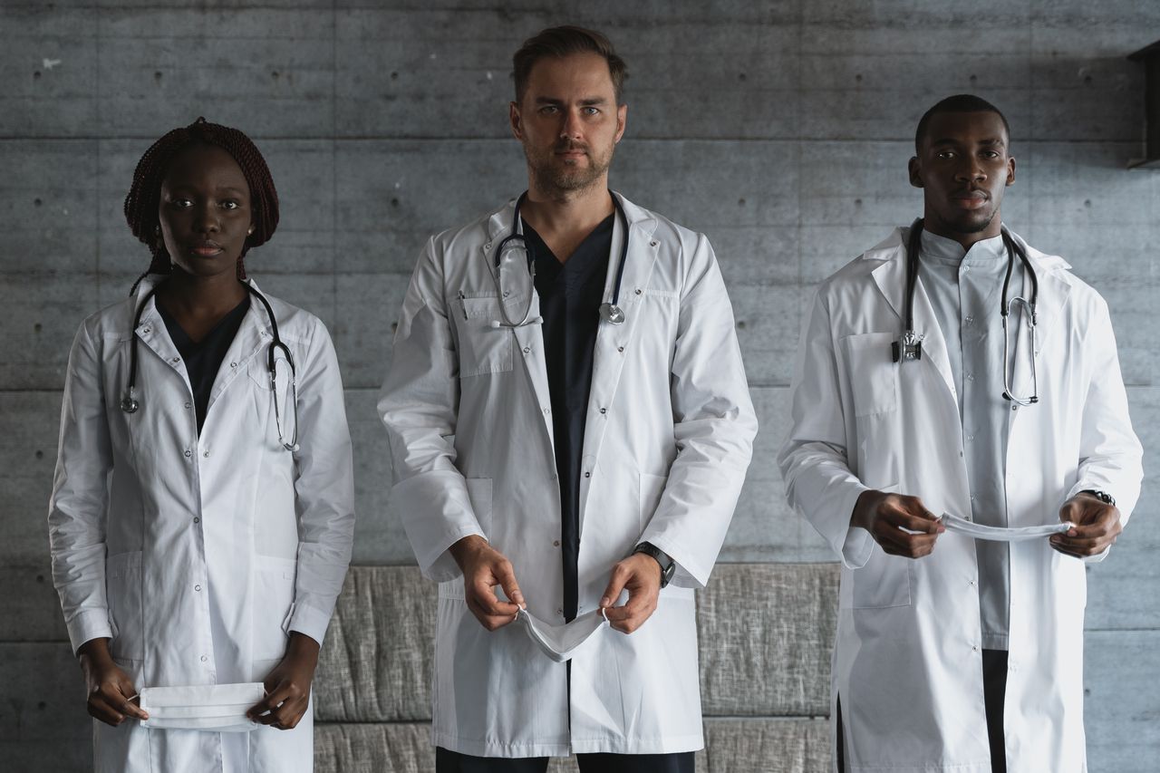 A diverse team of doctors in medical uniforms with stethoscopes in a hospital setting.